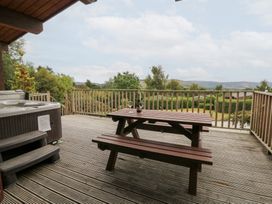 An outdoor patio with a hot tub and a dining table at Mountain View in Rhayader