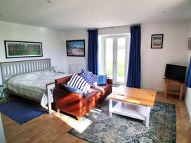 A living room with a bed, sofa, and coffee table at Buttercups at Midway Kington