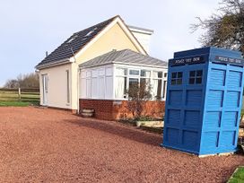 A house with a conservatory and a blue police box at Buttercups at Midway Kington