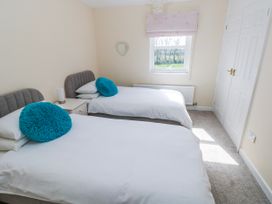A bedroom with two beds and a window at Mountain Farm in Broad Haven