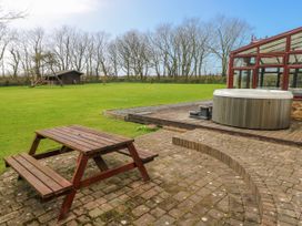 An outdoor area with a picnic table and hot tub at Mountain Farm in Broad Haven