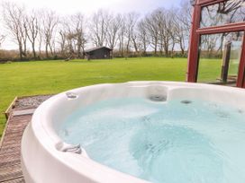 A hot tub with a view of the garden at Mountain Farm in Broad Haven
