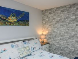 A bedroom with a bed and a bedside lamp at Hidden Treasure in Brixham