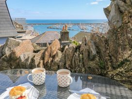 An outdoor scene with coffee cups and scones overlooking a marina at Hidden Treasure in Brixham