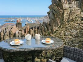 A table set with mugs and scones overlooking the harbor at Hidden Treasure in Brixham