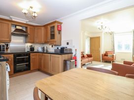 A kitchen with wooden cabinets and a dining table at 5 Styleman Road Hunstanton