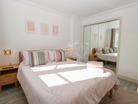 A bedroom with a bed and mirrored wardrobe at 5 Styleman Road, Hunstanton