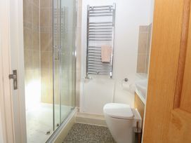 A bathroom with a shower, toilet, towel warmer, and sink at 5 Styleman Road, Hunstanton