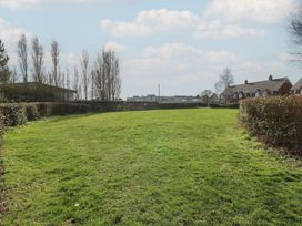 An open area with grass and hedges near houses at 5 Styleman Road Hunstanton