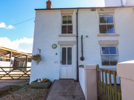 A front entrance with a door and windows at Tight Lyne Cottage in Longtown