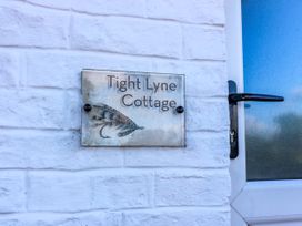 A nameplate for Tight Lyne Cottage next to a door at Tight Lyne Cottage Longtown