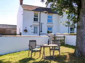 An outdoor seating area with a table and chairs at Tight Lyne Cottage in Longtown