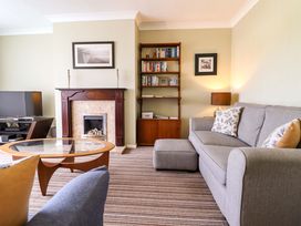A living room with a sofa and a television at Castle Cove in Abergele