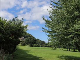 A golf course with trees and a flag at Castle Cove in Abergele