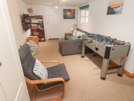 A game room with a foosball table and seating at Pilchard Cottage in Sennen Cove