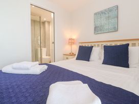 A bedroom with a bed and en-suite bathroom at Pilchard Cottage Sennen Cove