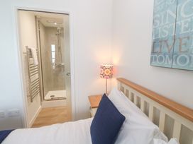 A bedroom with a shower and lamp at Pilchard Cottage in Sennen Cove