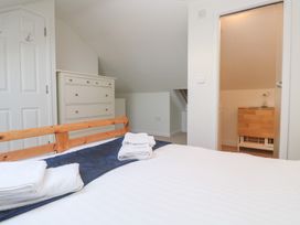 A bedroom with a bed and dresser at Pilchard Cottage Sennen Cove