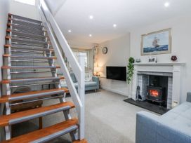 A living room with a staircase and fireplace at 3 Tyn Giat Penysarn near Amlwch