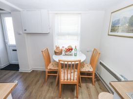 A kitchen with a dining table and chairs at 3 Tyn Giat Penysarn near Amlwch