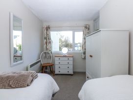 A bedroom with a bed, dresser, and window at 3 Tyn Giat Penysarn near Amlwch