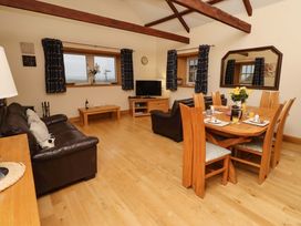 A living room with a sofa and dining table at Stable D'or in Embleton