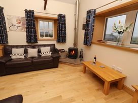 A living room with a sofa and a fireplace at Stable D'or in Embleton