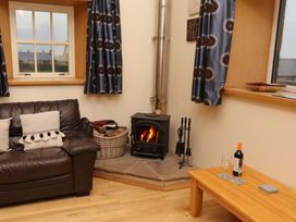 A living room with a sofa and a fireplace at Stable D'or in Embleton