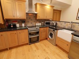 A kitchen with cabinets, an oven, a microwave, and a washing machine at Stable D'or, Embleton
