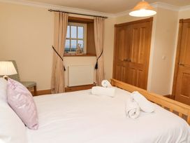 A bedroom with a bed and lamp at Stable D'or in Embleton