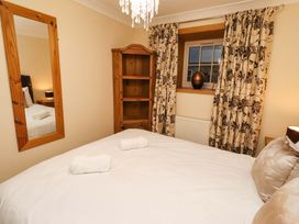 A bedroom with a bed and bookshelf at Stable D'or in Embleton