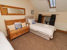A bedroom with a bed, bench, and mirror at Stable D'or in Embleton