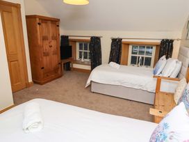 A bedroom with beds, a wardrobe, and a television at Stable D'or in Embleton