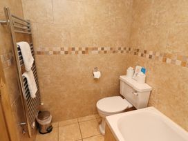 A bathroom with a toilet and bath tub at Stable D'or in Embleton