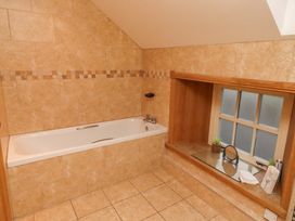 A bathroom with a bathtub and a washbasin at Stable D'or in Embleton