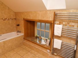 A bathroom with a bathtub and a towel radiator at Stable D'or in Embleton