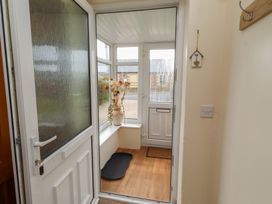 A conservatory with a door, window, and a vase at The Retreat in Embleton
