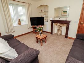 A living room with a television and a table at The Retreat in Embleton