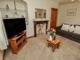 A living room with a television and sofa at The Retreat in Embleton