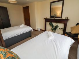 A bedroom with two beds and a wardrobe at The Retreat in Embleton