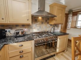 A kitchen with cabinets and a gas stove at Low Croft in Embleton