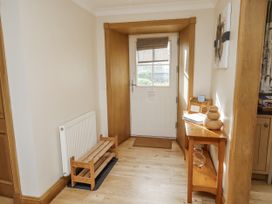 A hallway with a door and bench at Low Croft in Embleton