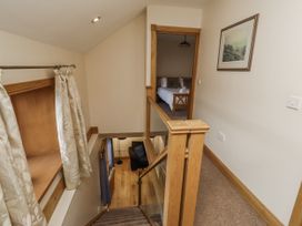 A hallway with a staircase and a doorway to a bedroom at Low Croft in Embleton