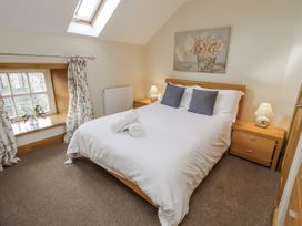 A bedroom with a double bed and window at Low Croft in Embleton