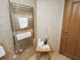 A bathroom with a towel rail and small table at Low Croft in Embleton