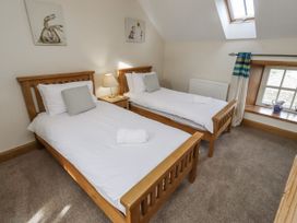 A bedroom with two single beds and a window at Low Croft in Embleton