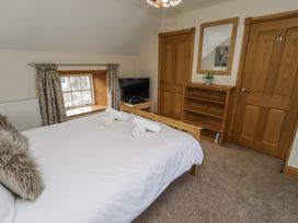 A bedroom with a bed and television at Low Croft in Embleton