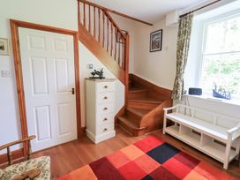 A hallway with a staircase and a chest of drawers at Drystones in Grasmere