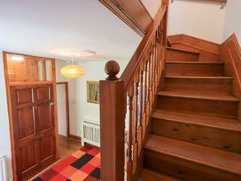 A hallway with a staircase and front door at Drystones in Grasmere