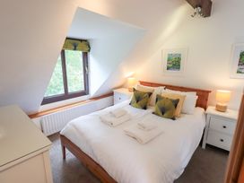 A bedroom with a bed and nightstands at Drystones in Grasmere